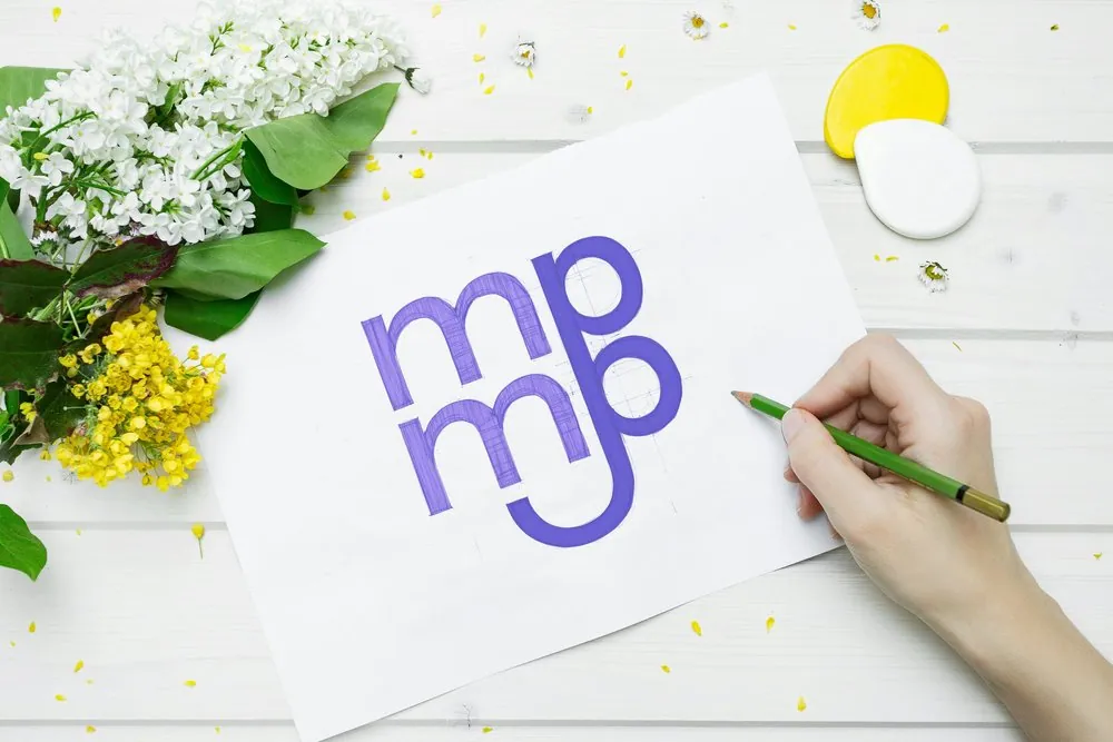 MMPP logo being drawn on paper with a green pencil